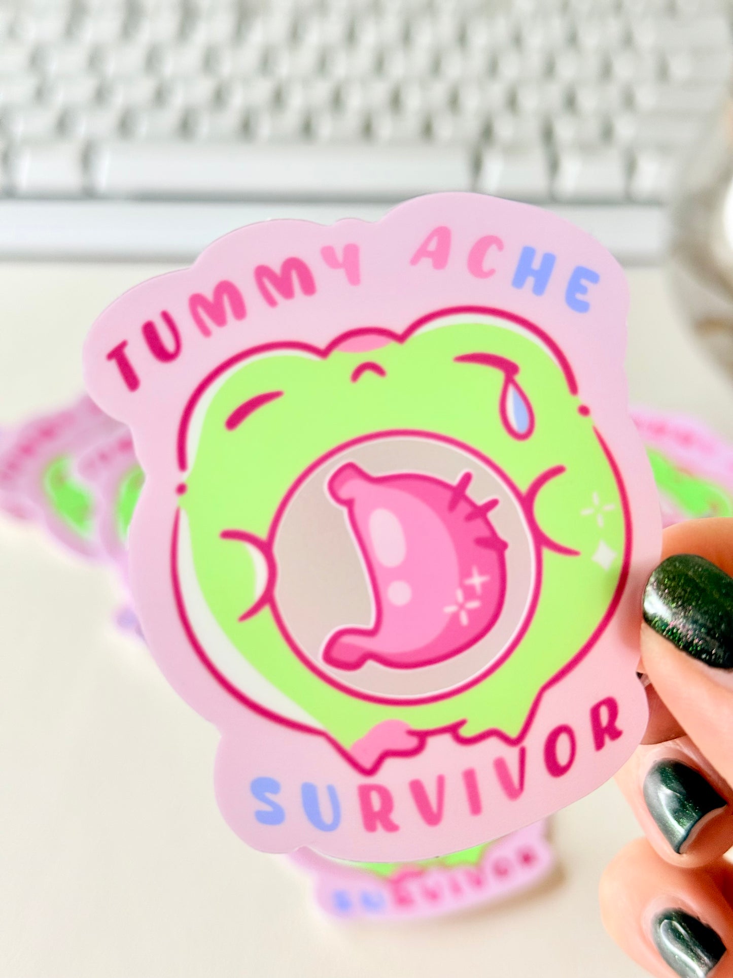 Tummy Ache Survivor Frog Sticker featuring Pastel pink and green frog sticker reading "Tummy Ache Survivor’ with a crying frog holding its stomach".