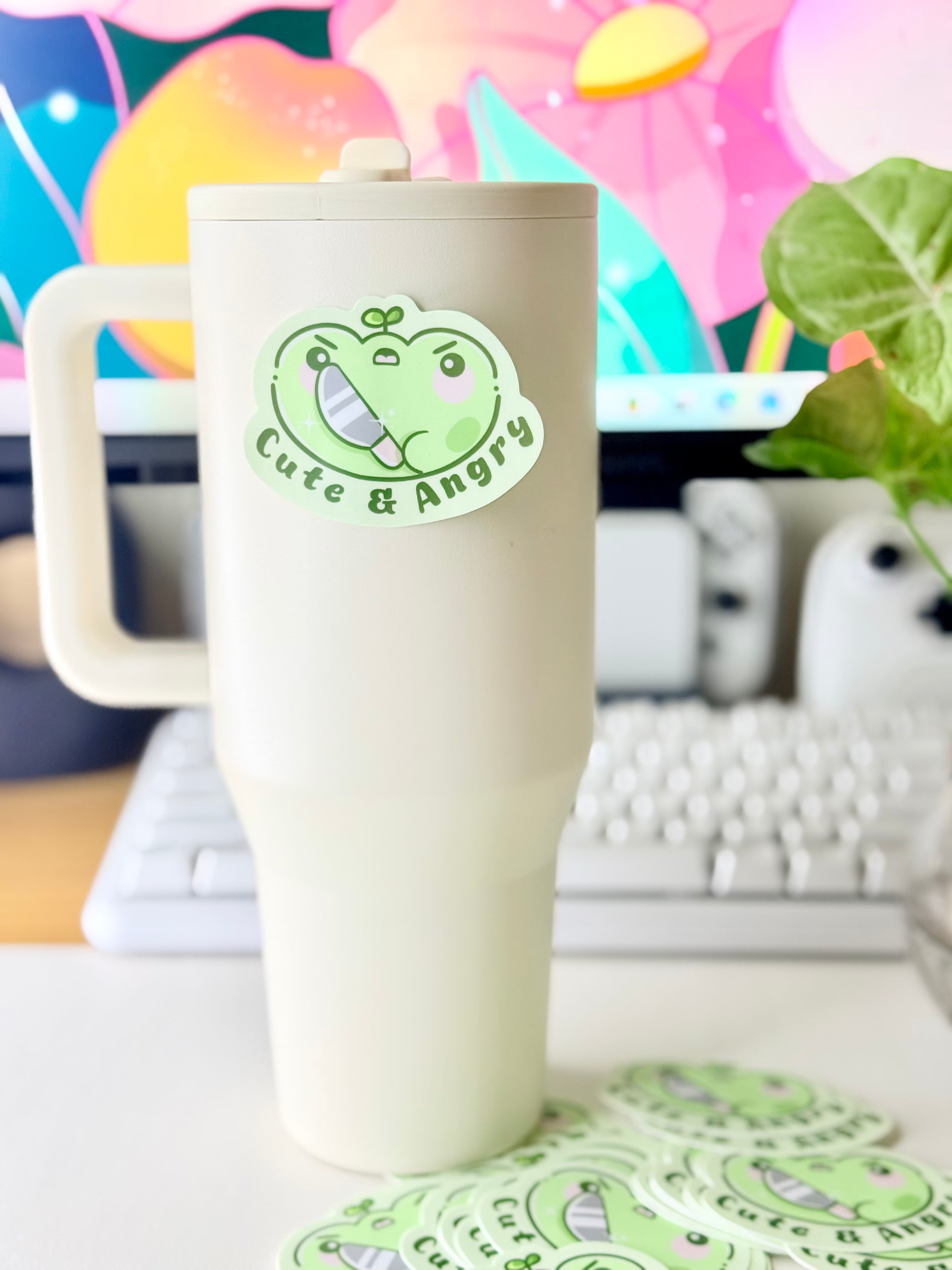 Cute & Angry Frog Vinyl Sticker featuring Light green frog sticker holding a knife with the words ‘Cute & Angry’ in dark green text".