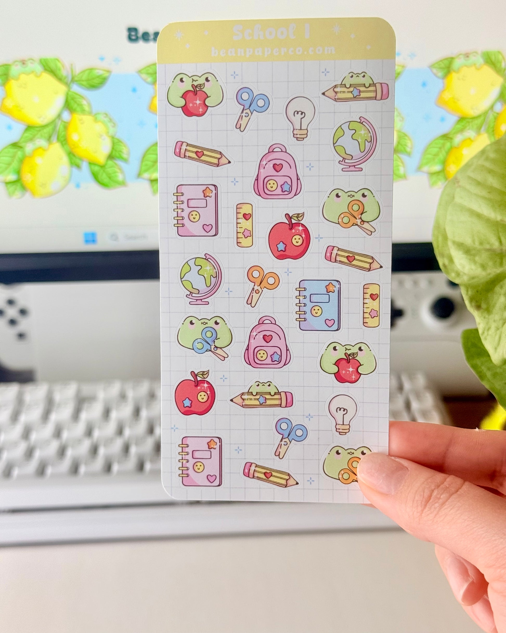 “School-themed frog sticker sheet featuring cute frogs with apples, pencils, scissors, backpacks, notebooks, rulers, and globes on a light grid background.”