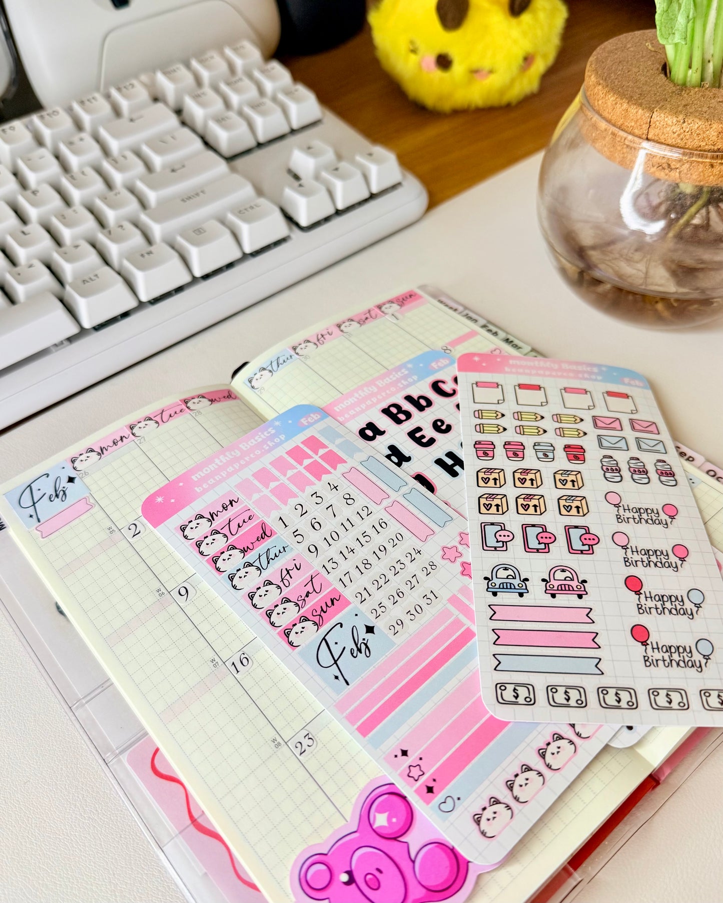 Hobonichi Weeks February Monthly Planner Sticker Kit featuring coffee cups, mail envelopes, package boxes, cars, water bottles, pencils, and birthday balloon stickers in pastel pink and blue.