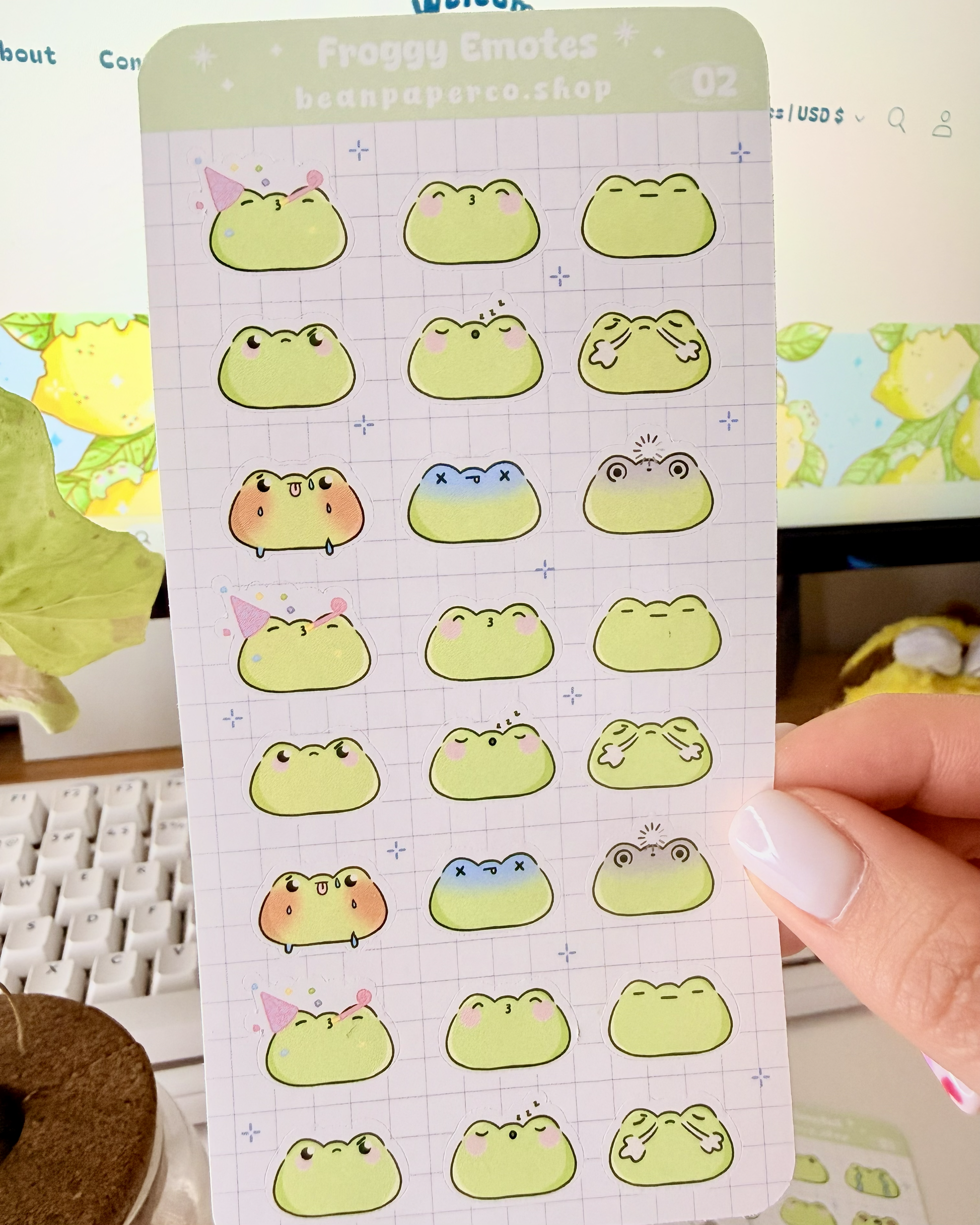 Cute Frog Emote Planner Stickers Vol. 2 featuring cute green frog faces with party hat, blushing, sleepy, angry, shocked, and fainting expressions on a light grid background.”