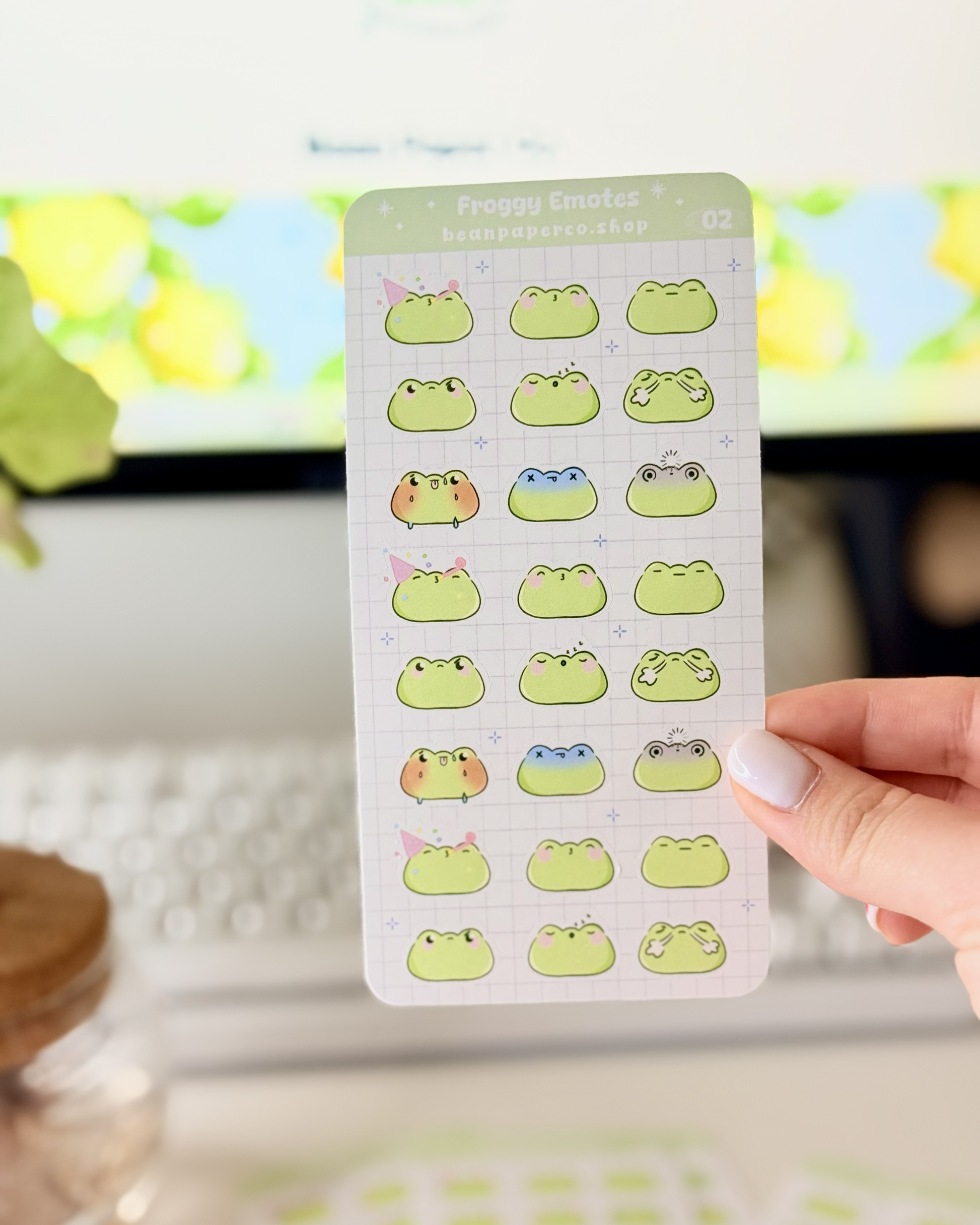 Cute Frog Emote Planner Stickers Vol. 2 featuring cute green frog faces with party hat, blushing, sleepy, angry, shocked, and fainting expressions on a light grid background.”