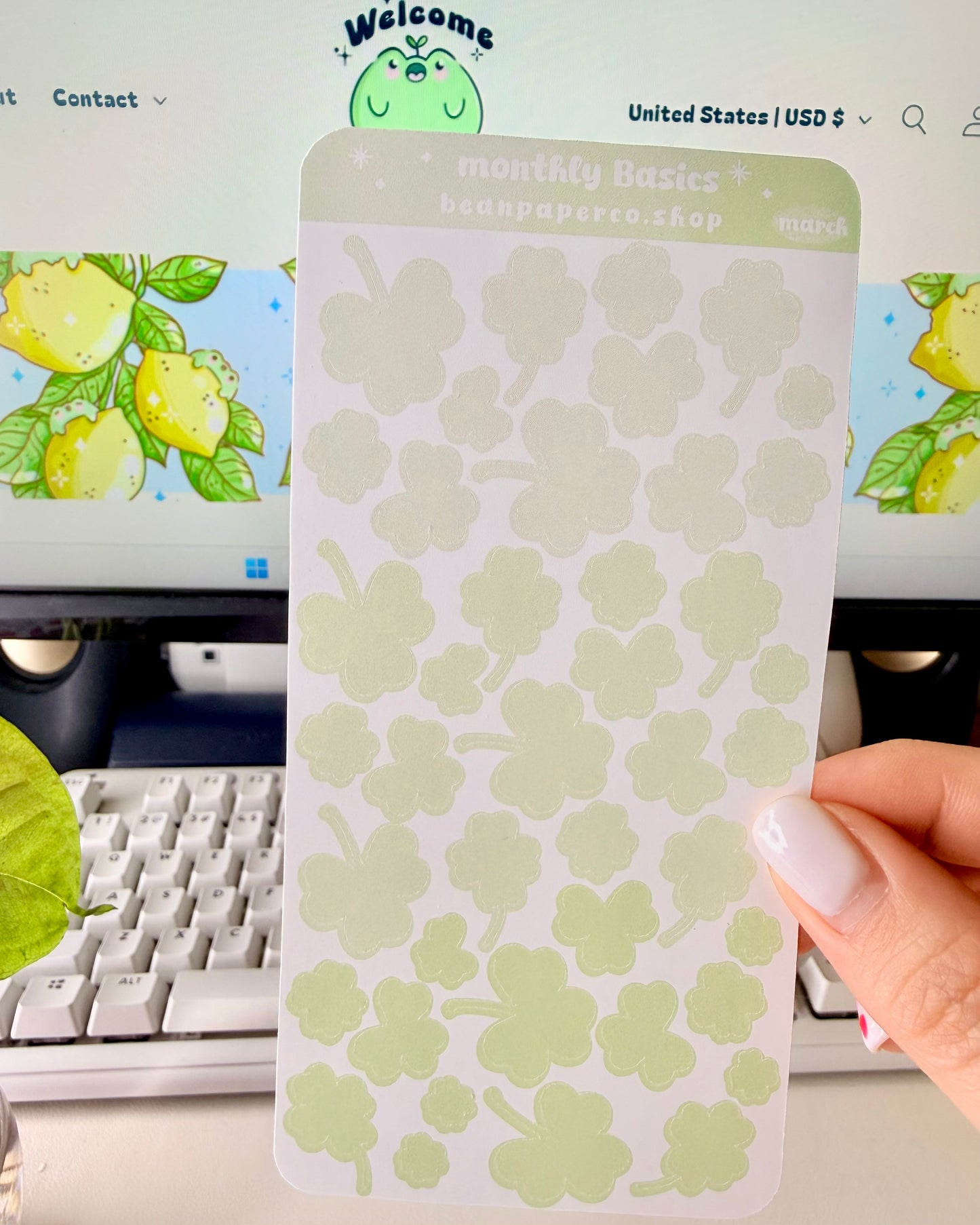 Cute March Clover Sticker Sheet held by hand featuring green ombre clovers.