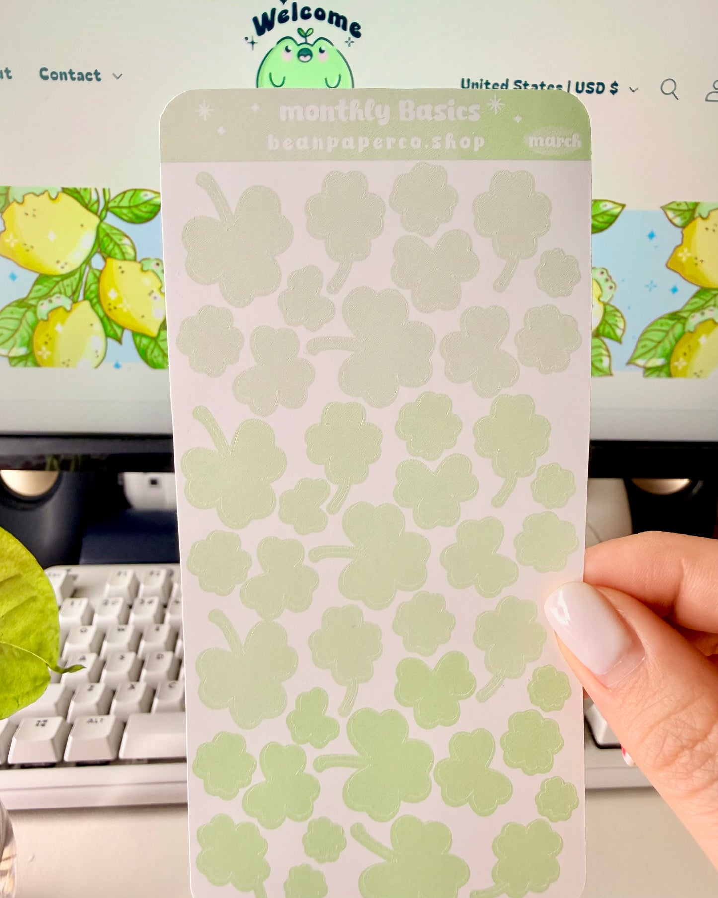 Cute March Clover Sticker Sheet held by hand featuring green ombre clovers.