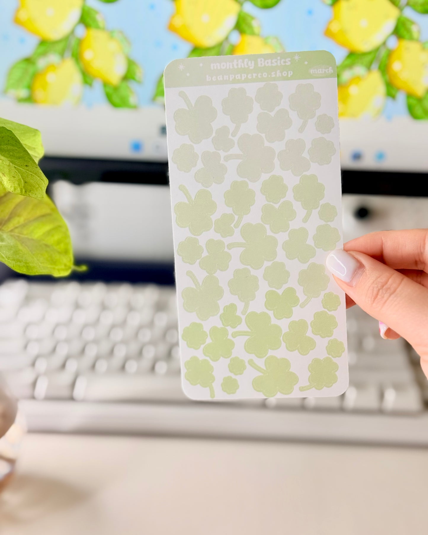 Cute March Clover Sticker Sheet held by hand featuring green ombre clovers.