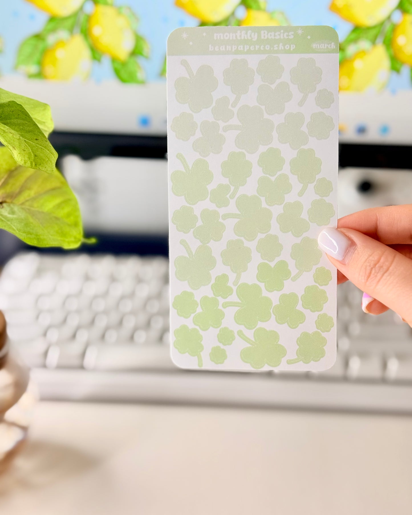 Cute March Clover Sticker Sheet held by hand featuring green ombre clovers.