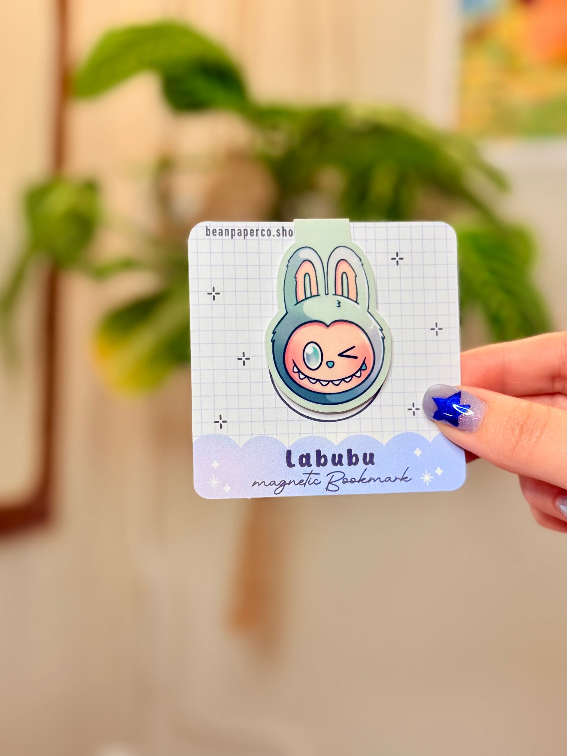 Labubu The Monsters Magnetic Bookmark design displayed in a hand with vibrant colors and a cute bunny character.