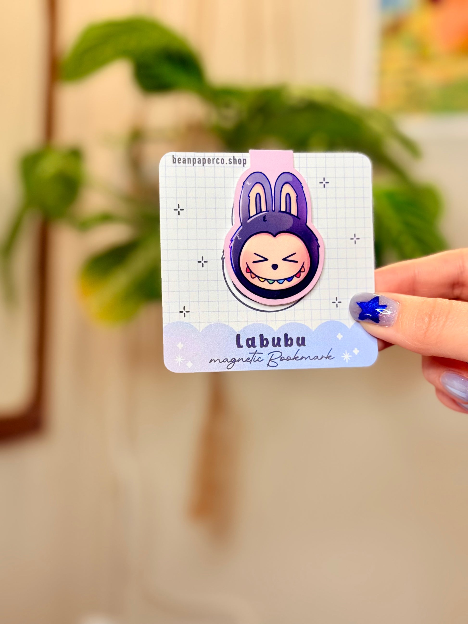 Labubu The Monsters Magnetic Bookmark design displayed in a hand with vibrant colors and a cute bunny character.