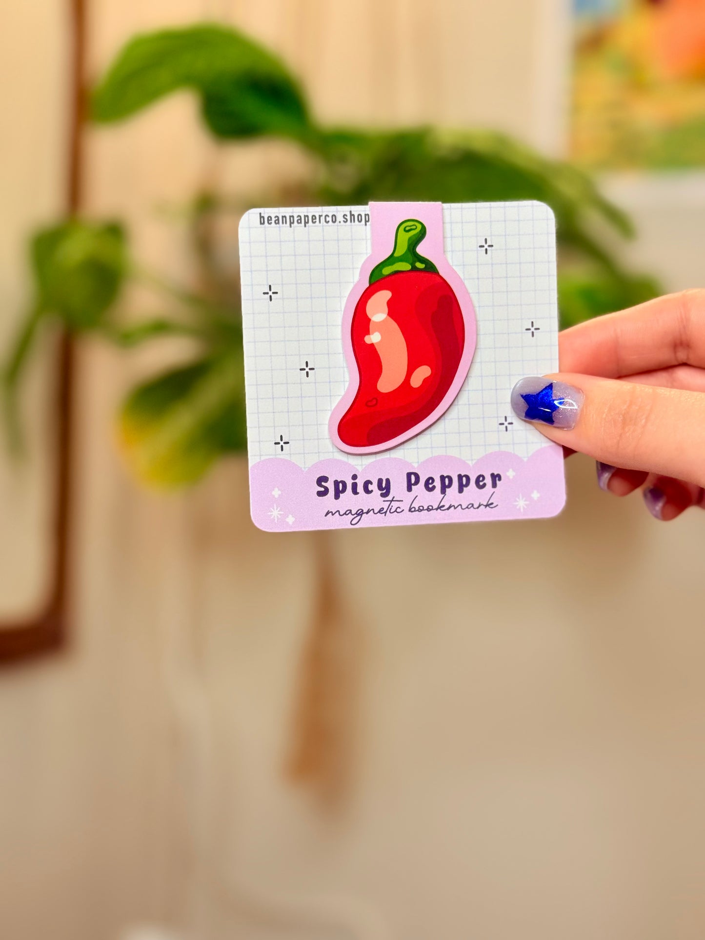 Spicy Pepper Magnetic Bookmark held in hand, featuring a vibrant red pepper design on a pastel background.