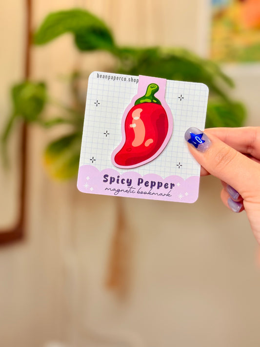 Spicy Pepper Magnetic Bookmark featuring a colorful chili pepper design held in hand, ideal for adding flair to reading.