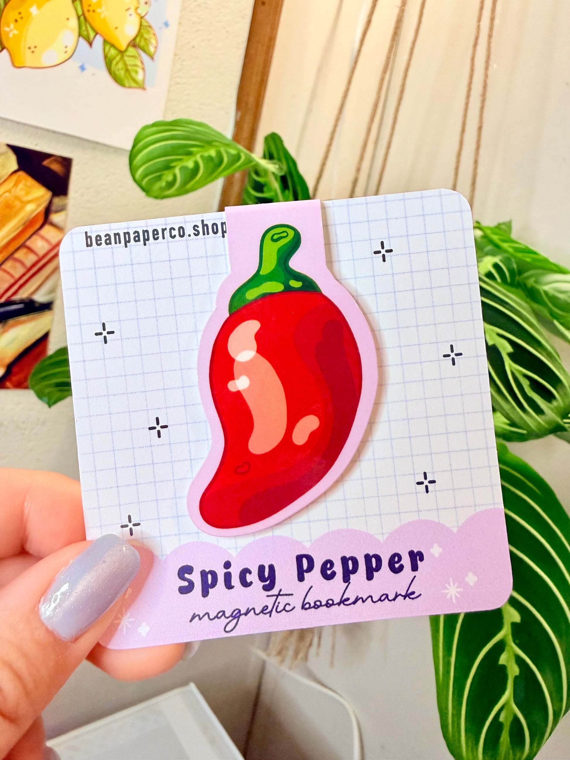 Spicy Pepper Magnetic Bookmark featuring a red pepper design on a grid background, perfect for adding spice to reading.