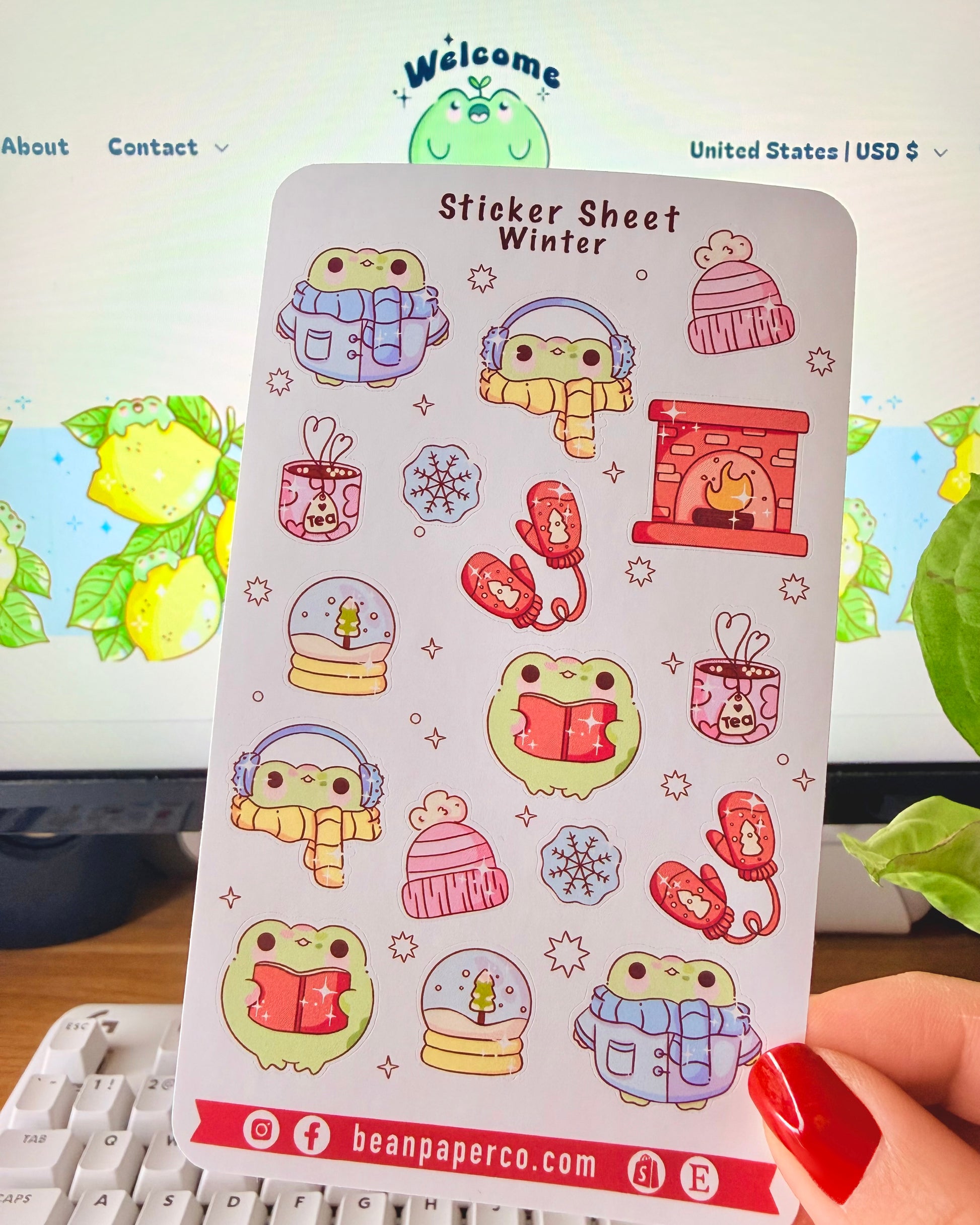 “Winter frog sticker sheet featuring frogs in scarves and earmuffs, mittens, snow globes, tea mugs, hats, snowflakes, and a cozy fireplace.”