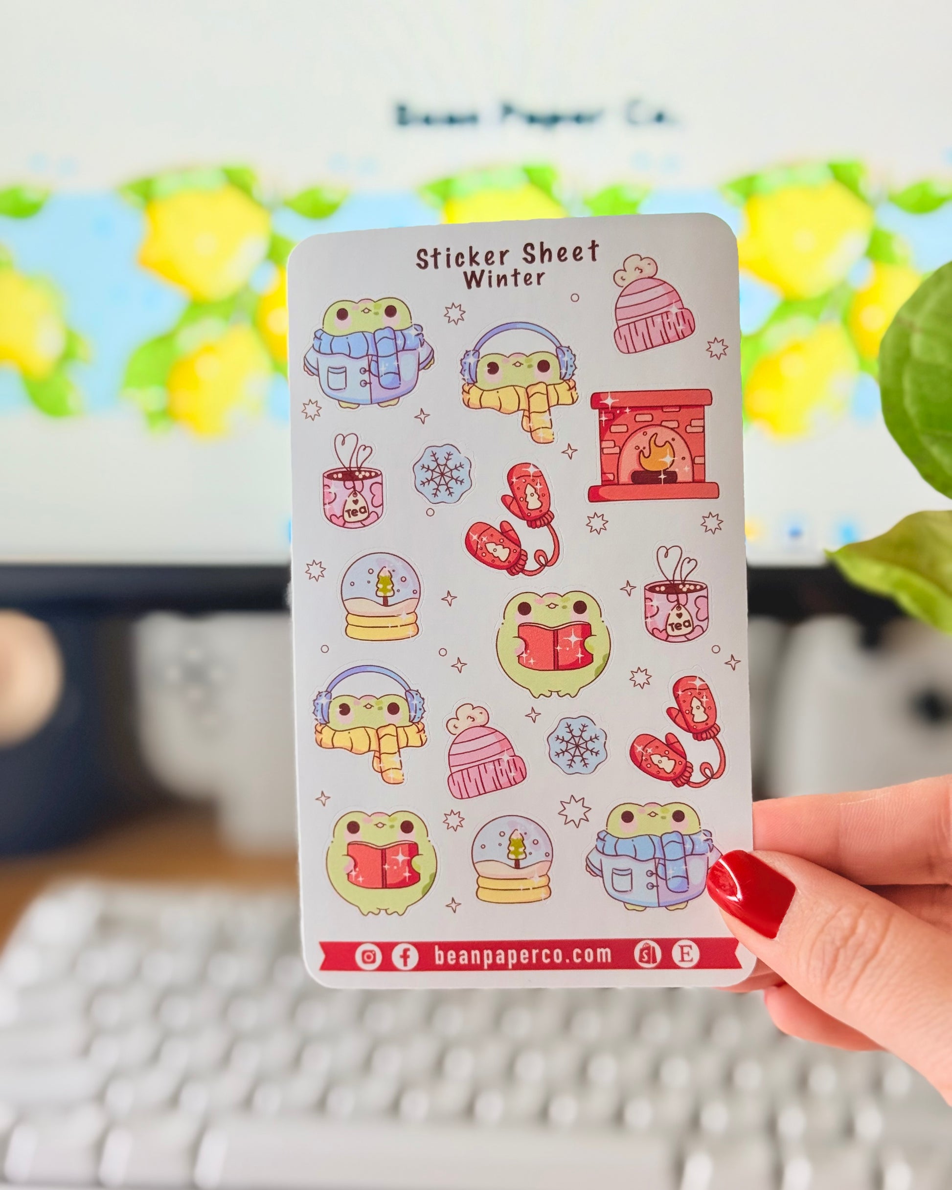 “Winter frog sticker sheet featuring frogs in scarves and earmuffs, mittens, snow globes, tea mugs, hats, snowflakes, and a cozy fireplace.”