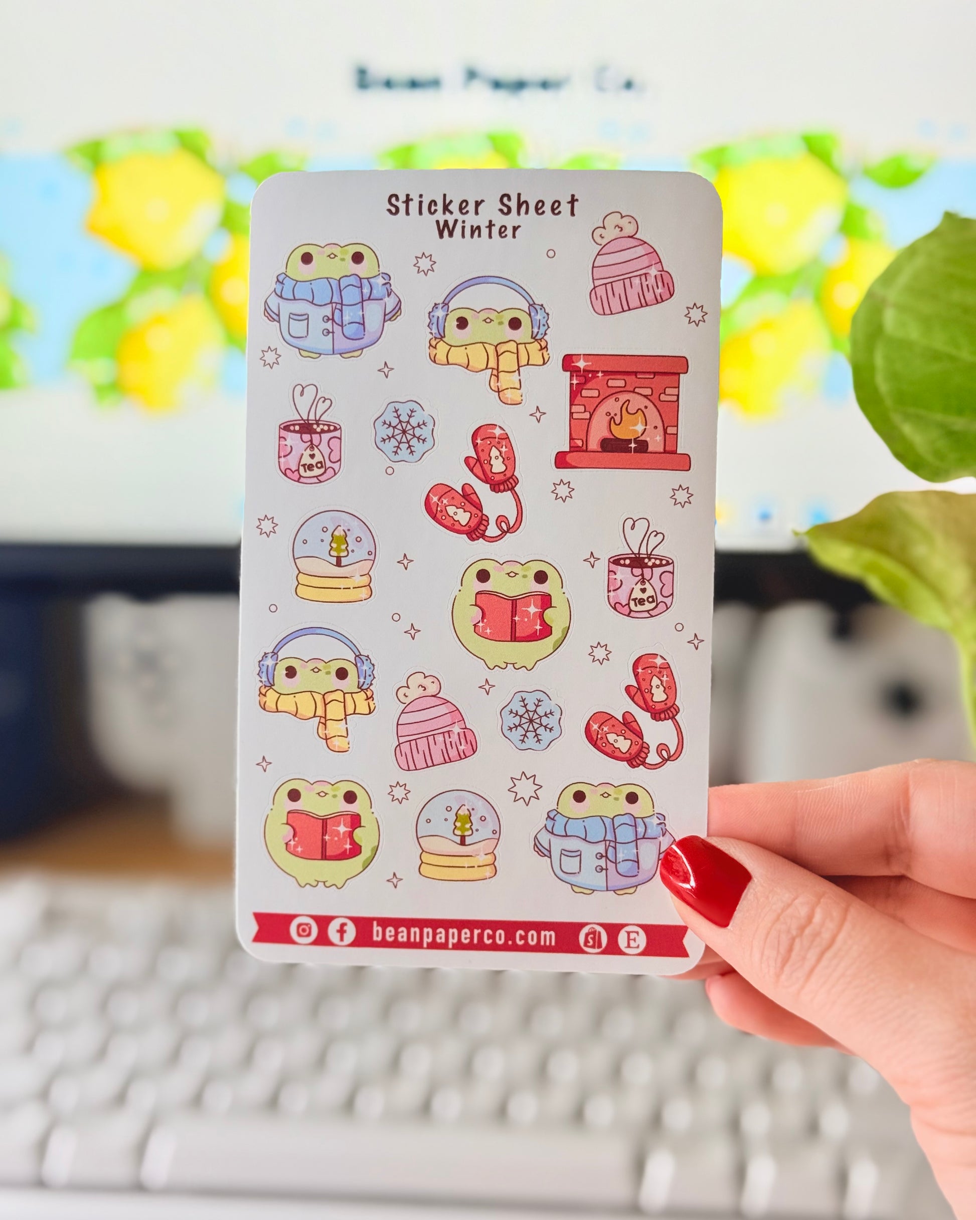 “Winter frog sticker sheet featuring frogs in scarves and earmuffs, mittens, snow globes, tea mugs, hats, snowflakes, and a cozy fireplace.”